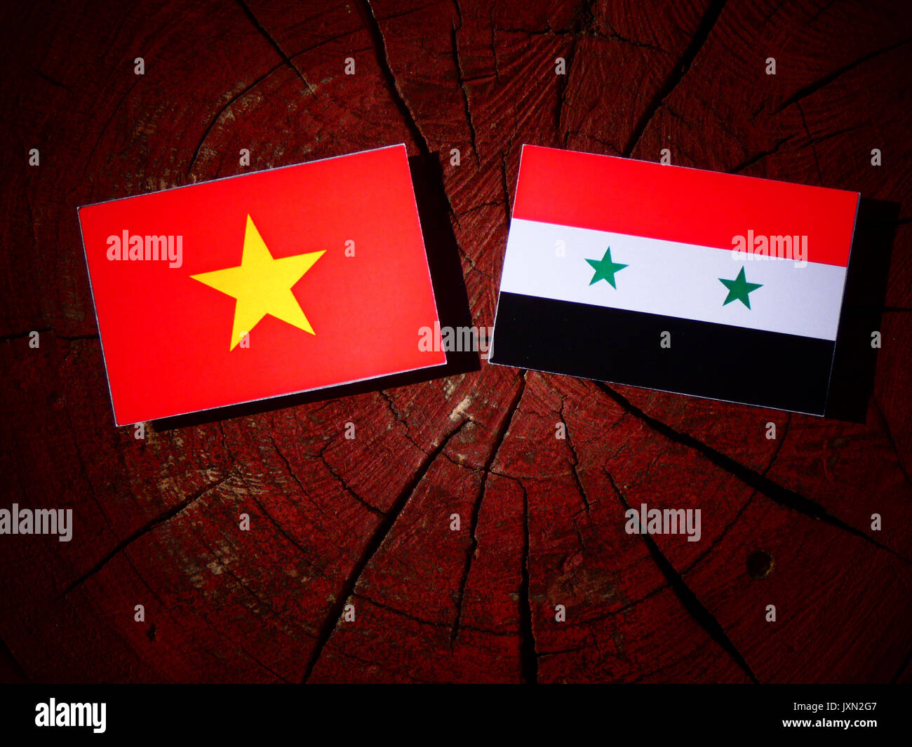 Vietnamese flag with Syrian flag on a tree stump isolated Stock Photo