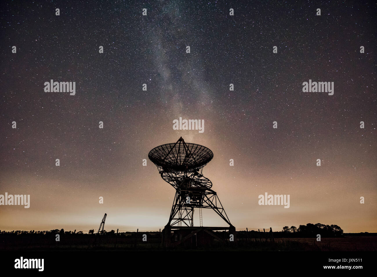 Milky Way behind a radio telescope dish of the Mullard Radio Astronomy Observatory, of the University of Cambridge Stock Photo