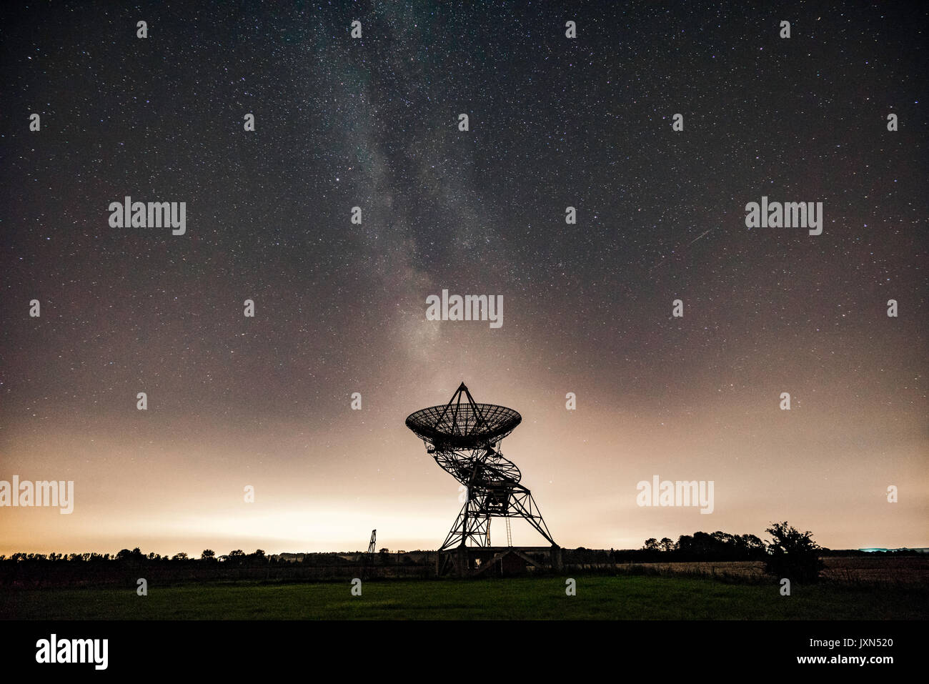 Milky Way behind a radio telescope dish of the Mullard Radio Astronomy Observatory, of the University of Cambridge Stock Photo