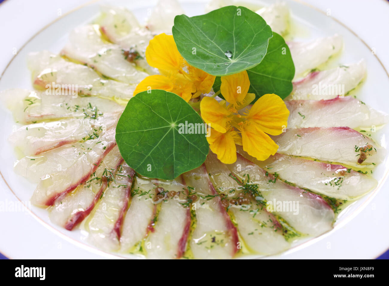fish carpaccio, thinly sliced raw sea bream appetizer, italian dish