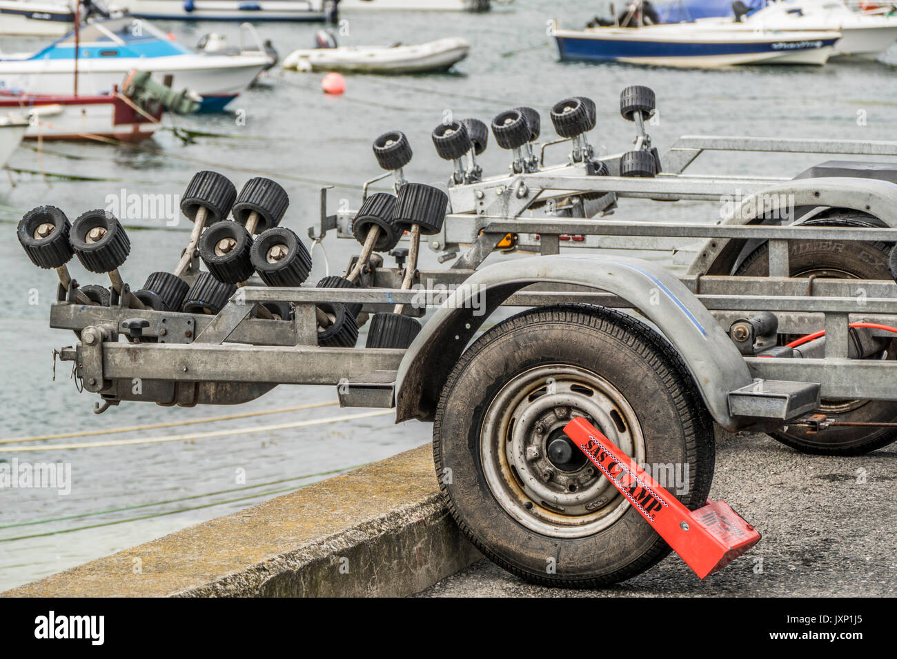 A boat trailer parked with an attached wheel clamp in Penzance harbour