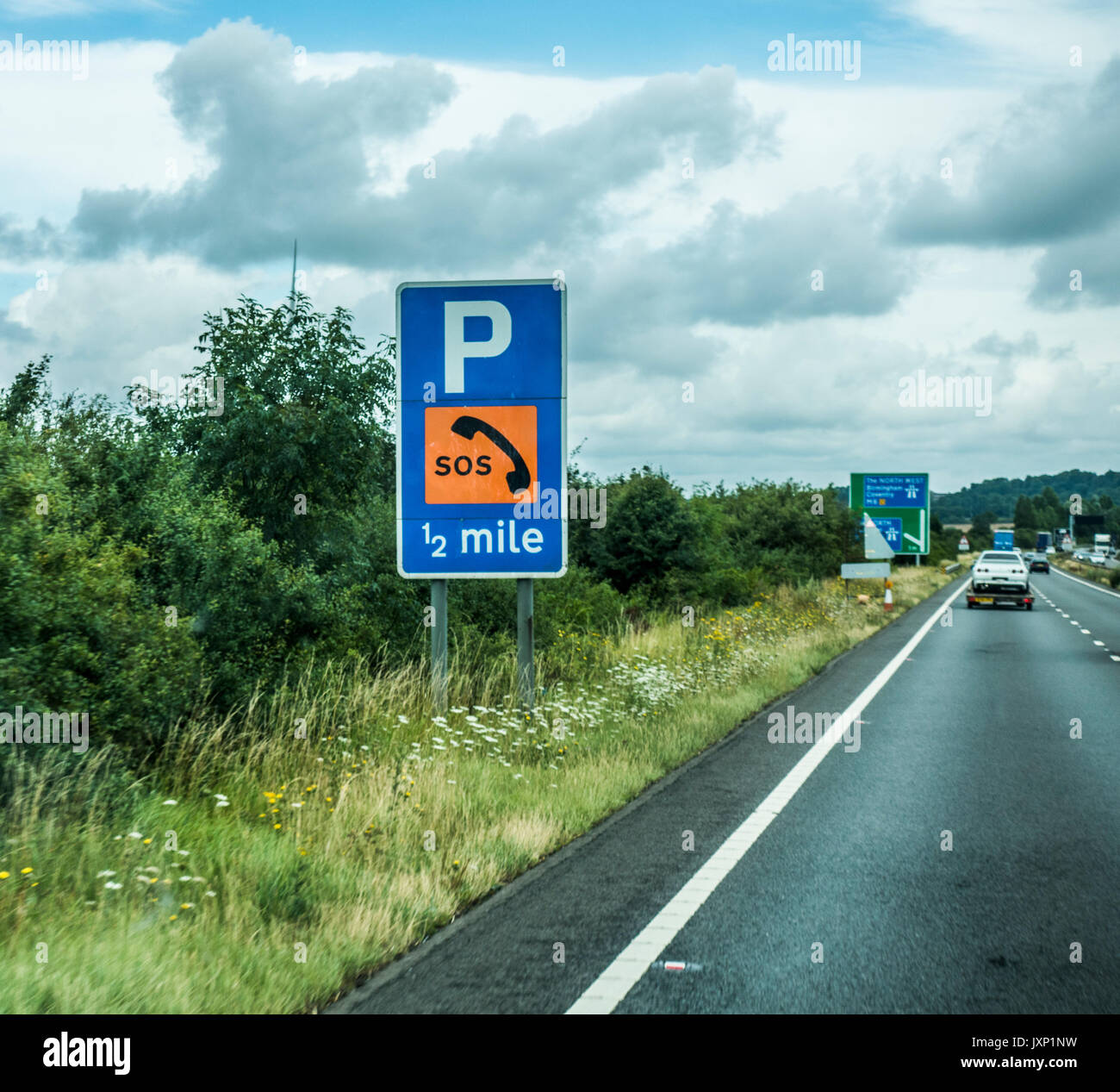 SOS sign for telephone and emergency parking on the M6 motorway in the East Midlands, heading west towards Birmingham and Coventry, England, UK. Stock Photo