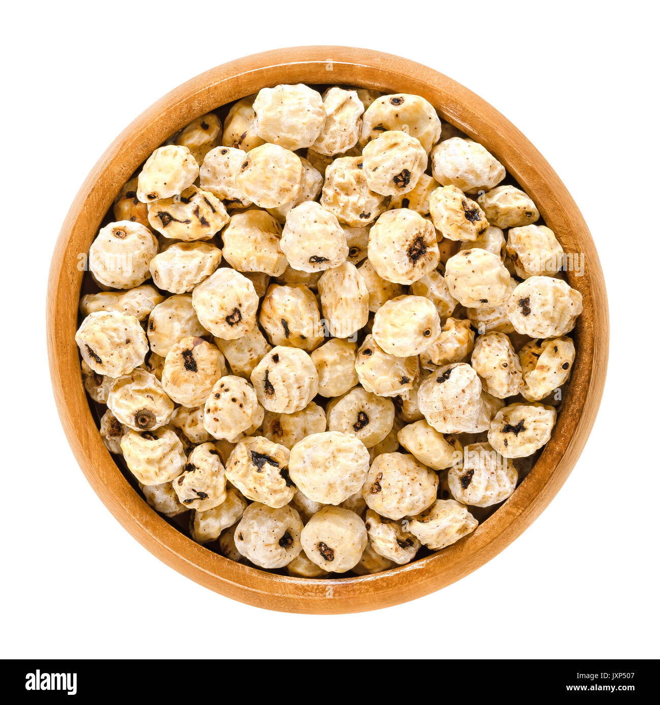 Tiger nuts in wooden bowl. Blanched and dried tubers of Cyperus esculentus. Earth almond, chufa sedge, nut grass or yellow nutsedge. Macro food photo. Stock Photo