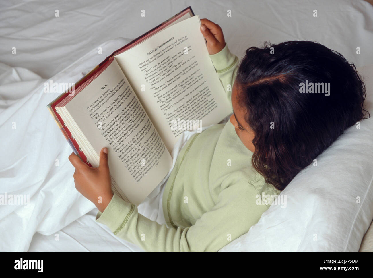 Young Girl 7-10 year old reading book in bed African American/Caucasian © Myrleen Pearson Stock Photo