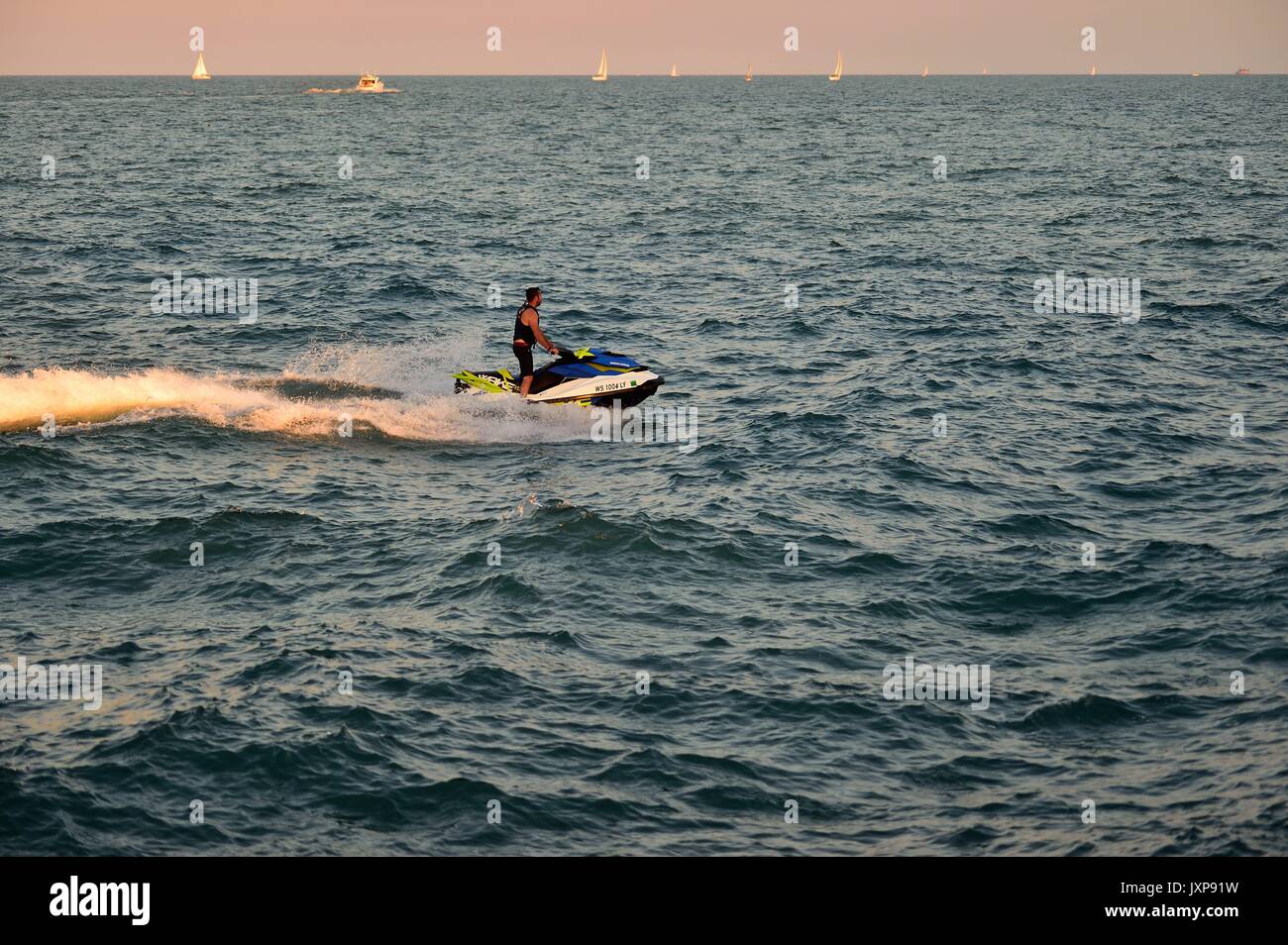 Man piloting a watercraft on Lake Michigan just outside Chicago's Diversey Harbor. Chicago, Illinois, USA. Stock Photo