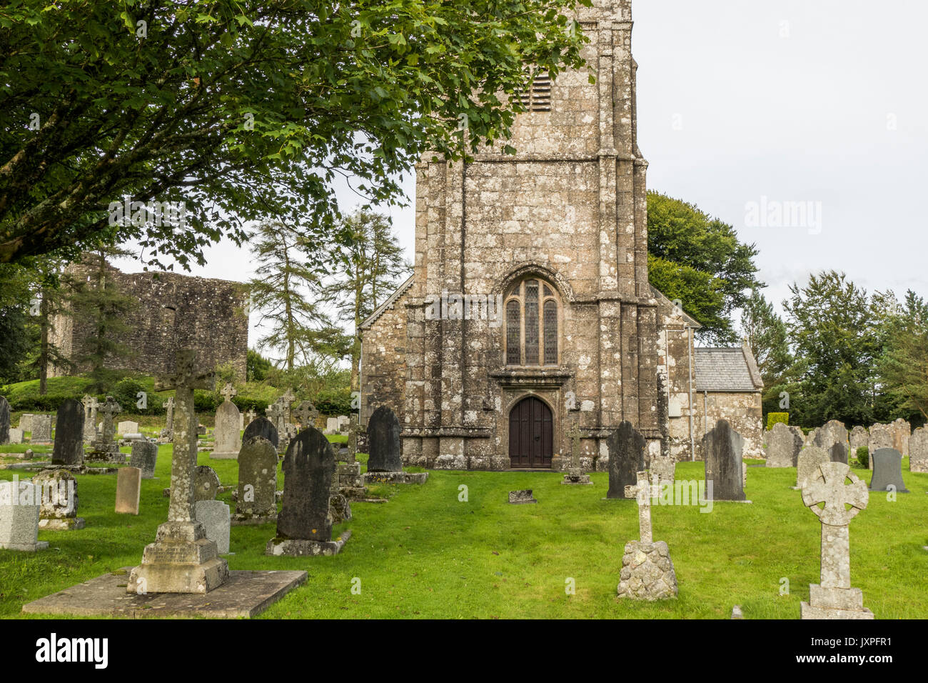 Historic Lydford Church and cemetery, with the castle in the background, Lydford, near Okehampton, Devon, England, UK. Stock Photo