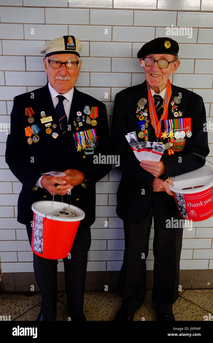 Military and Naval war veterans collecting at Westminster tube station for their taxi charity. Each had a bookmark with their service photo on it. Stock Photo