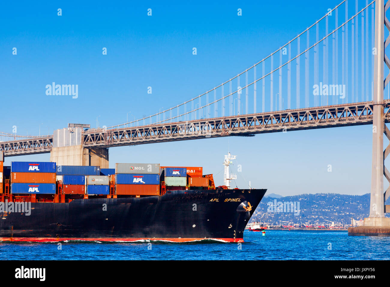 SAN FRANCISCO-AUG 11: A loaded container ship heads under the Bay Bridge toward the Oakland Port, in San Francisco on Aug. 11, 2012.  The Oakland Cont Stock Photo