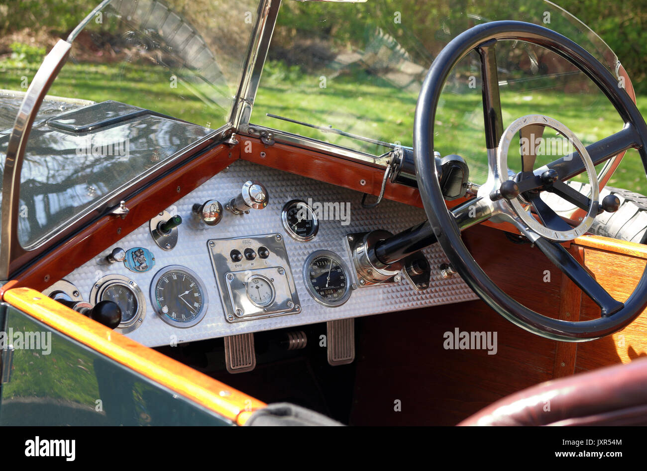Vintage Motor Car dashboard displaying dials and steering wheel Stock Photo