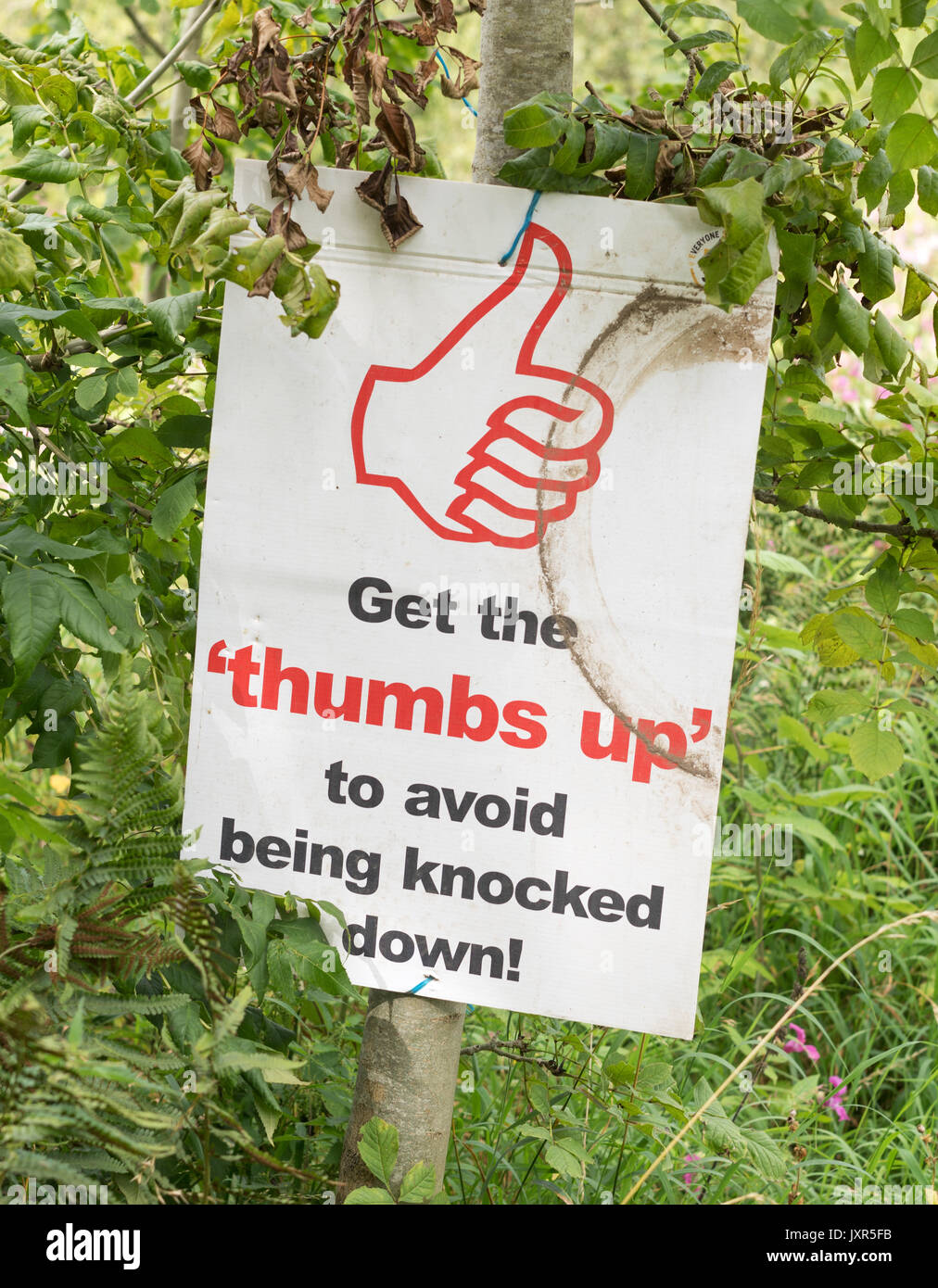 Building contractor's sign Get the thumbs up to avoid being knocked down, England, UK Stock Photo