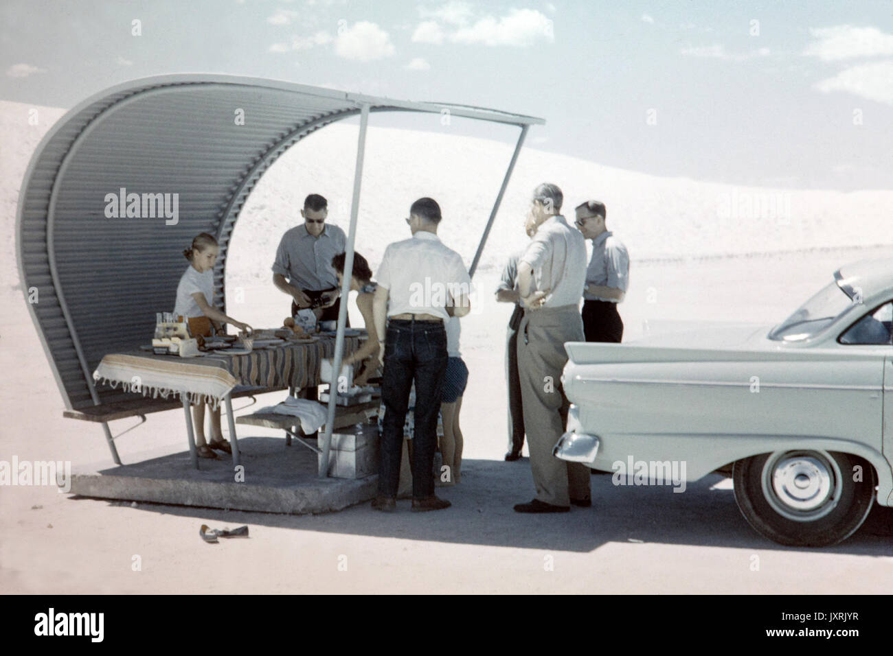 Vintage photo of an American family having a picnic and Barbecue at White Sands National Monument, New Mexico,  in 1956. Shows an awning and car of the period, together with fashion of the period. Stock Photo