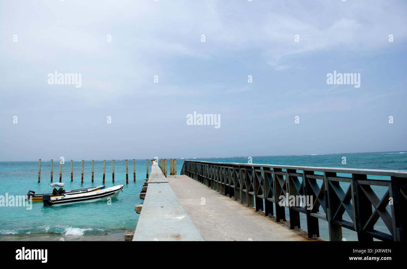 Tropical resort destination dock pier with little boats. Stock Photo