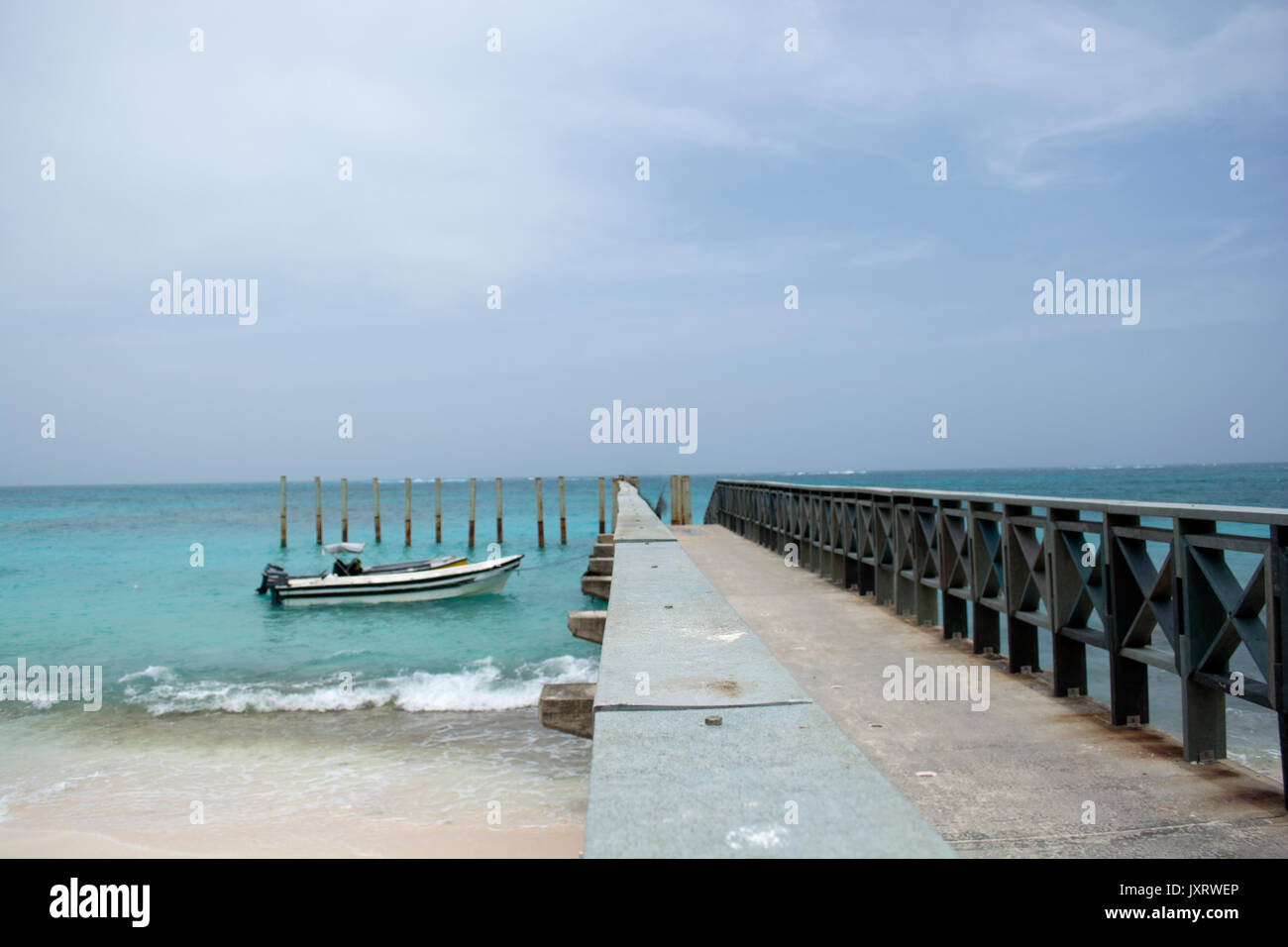 Tropical resort destination dock pier with little boats. Stock Photo