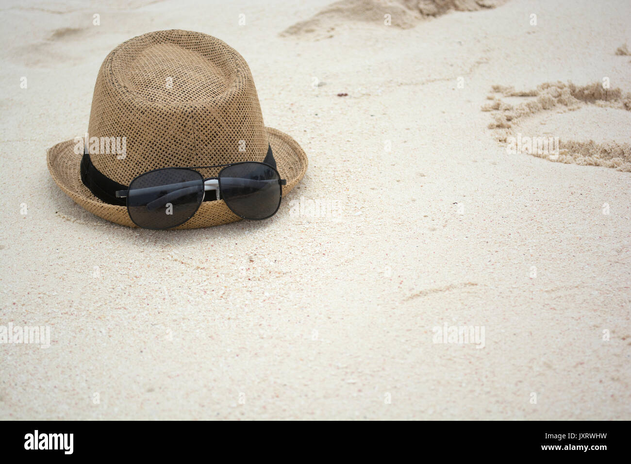 Summer hat and sunglasses on a sunny beach. Stock Photo