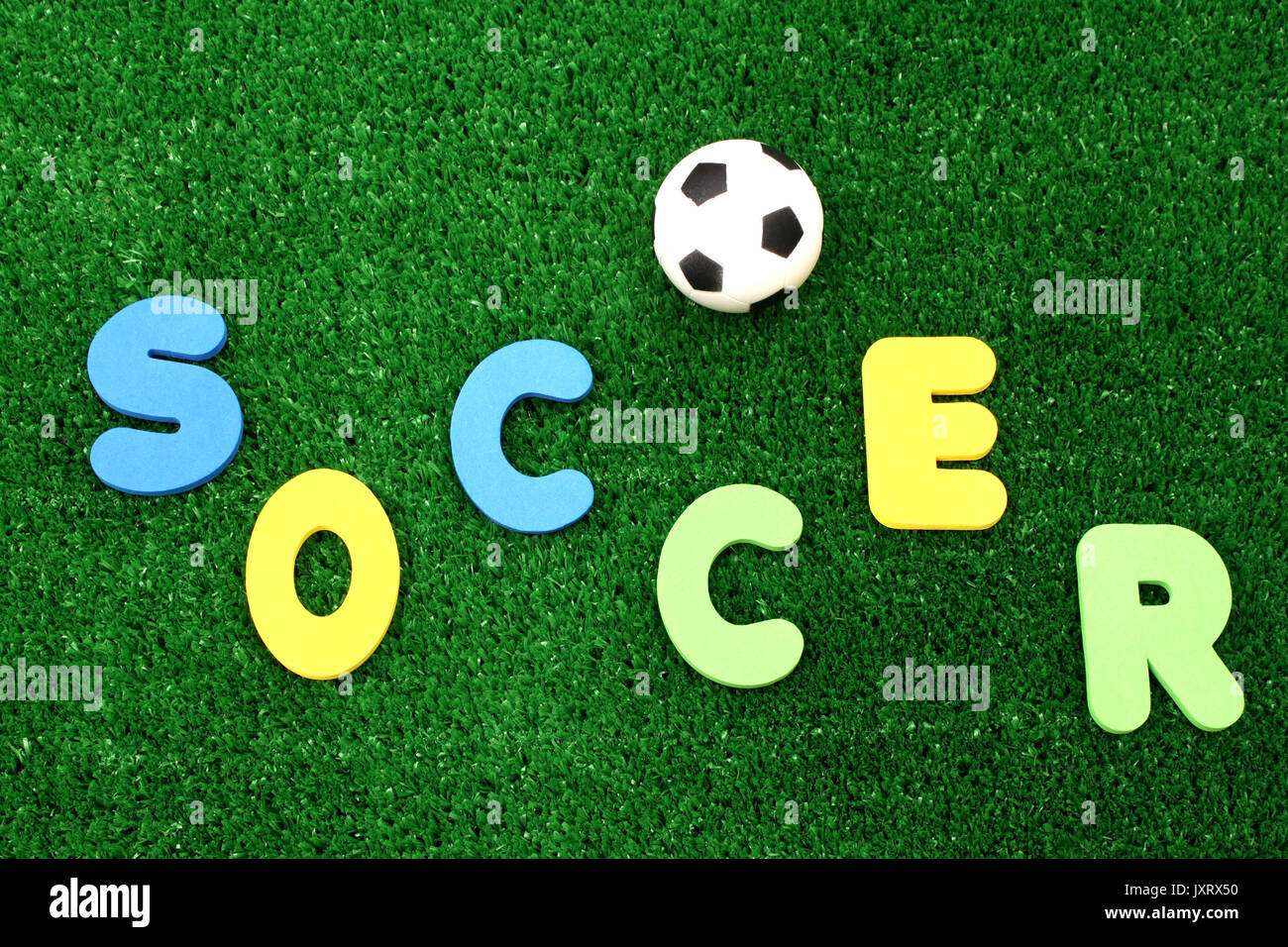 Soccer ball on atificial turf - word plastic colours Stock Photo