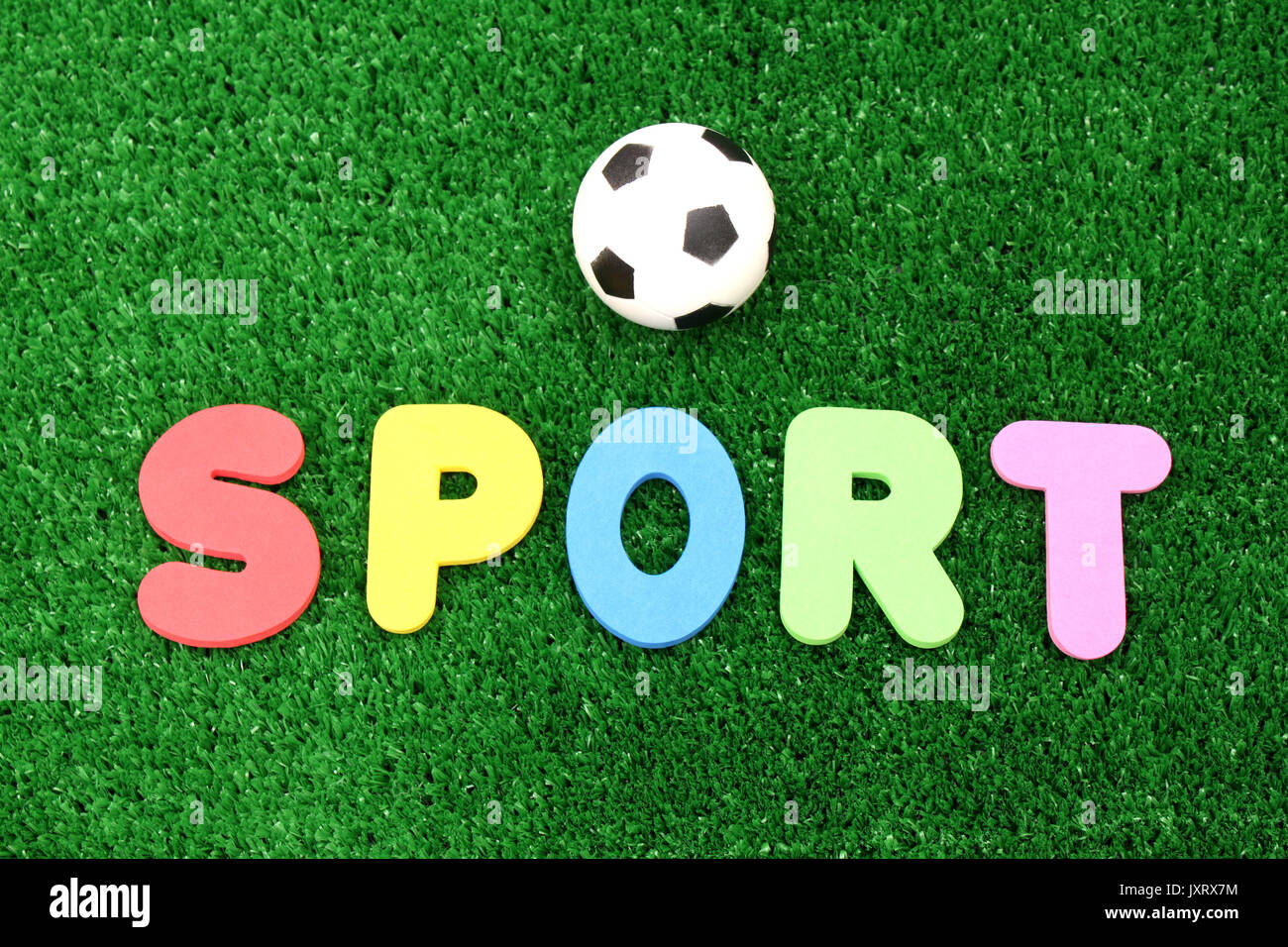 Soport ball on atificial turf - word plastic colours Stock Photo