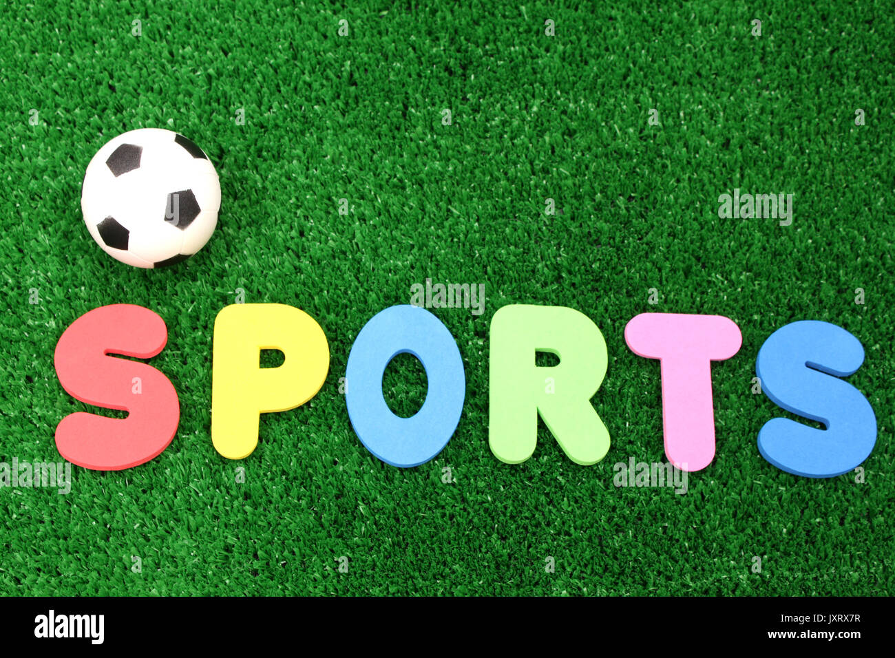 Sports ballon atificial turf - word plastic colours Stock Photo