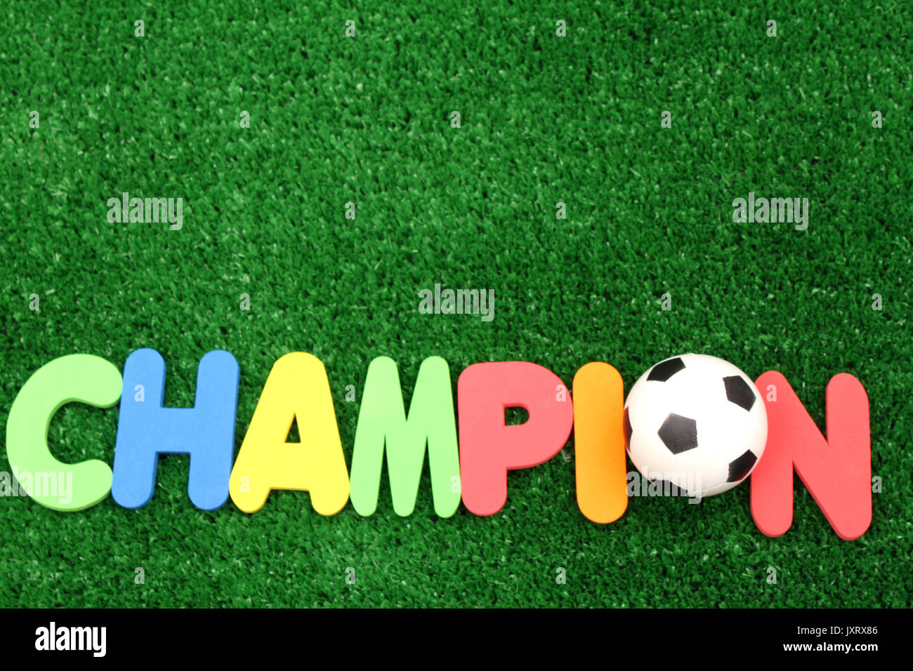 Champion ball on atificial turf - word plastic colours Stock Photo