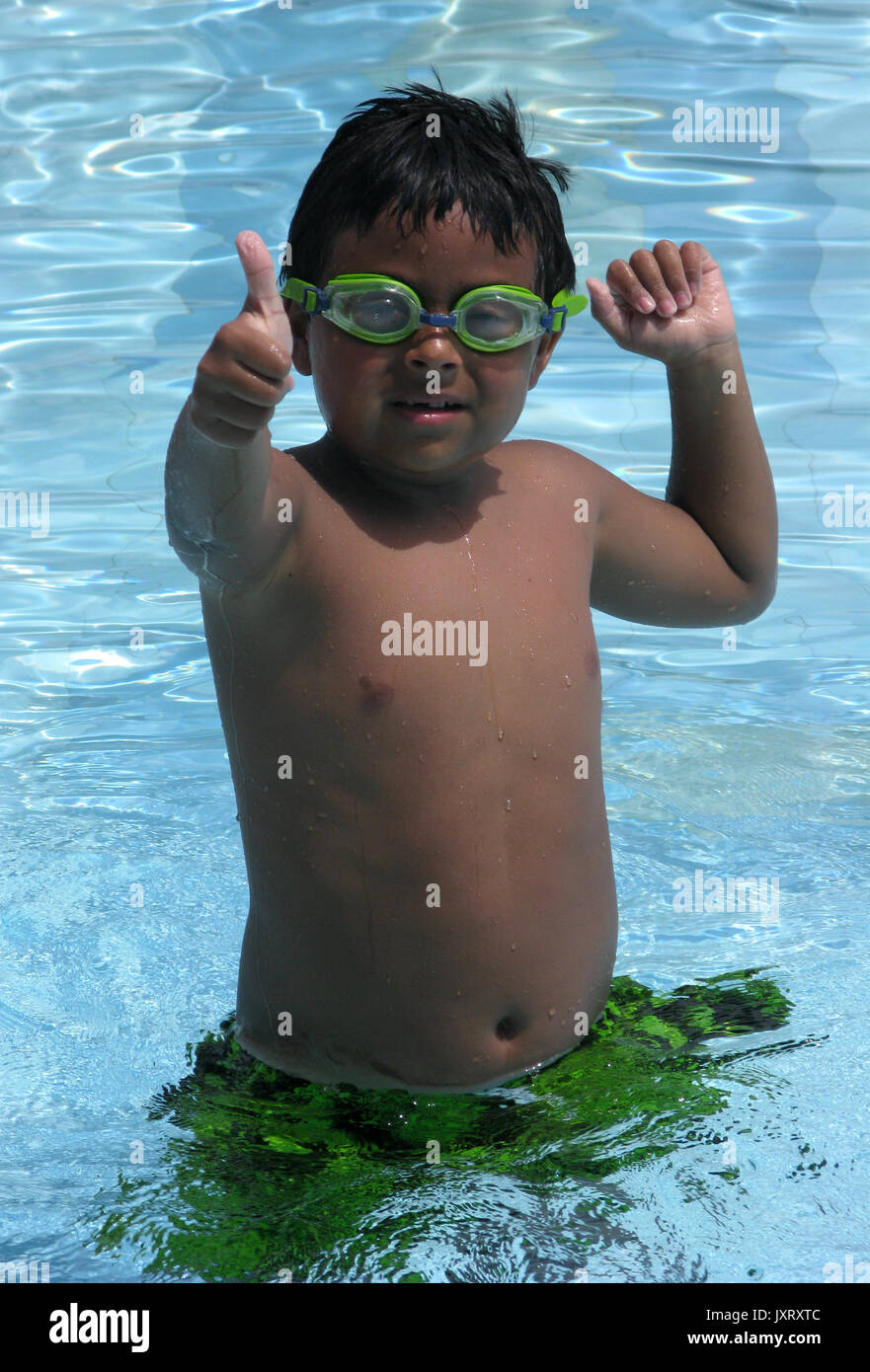 Smiling boy in a swimming pool with goggles Stock Photo