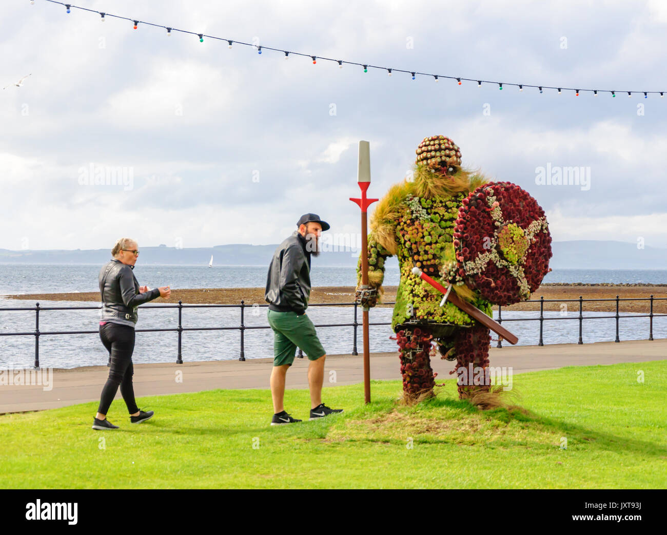 Largs, Scotland, UK. 17th August, 2017. UK Weather: A giant statue of Magnus the Viking made of flowers on the promenade enjoying sunny intervals and occasional heavy showers at the seaside in the west coast of Scotland resort town. The Vikings were defeated at the Battle of Largs in 1263, their last raid on Scottish soil, under the treaty of Perth Magnus the King of Norway surrendered the Western Isles and the Isle of Man to the Scottish Crown in 1266. Credit: Skully/Alamy Live News Stock Photo