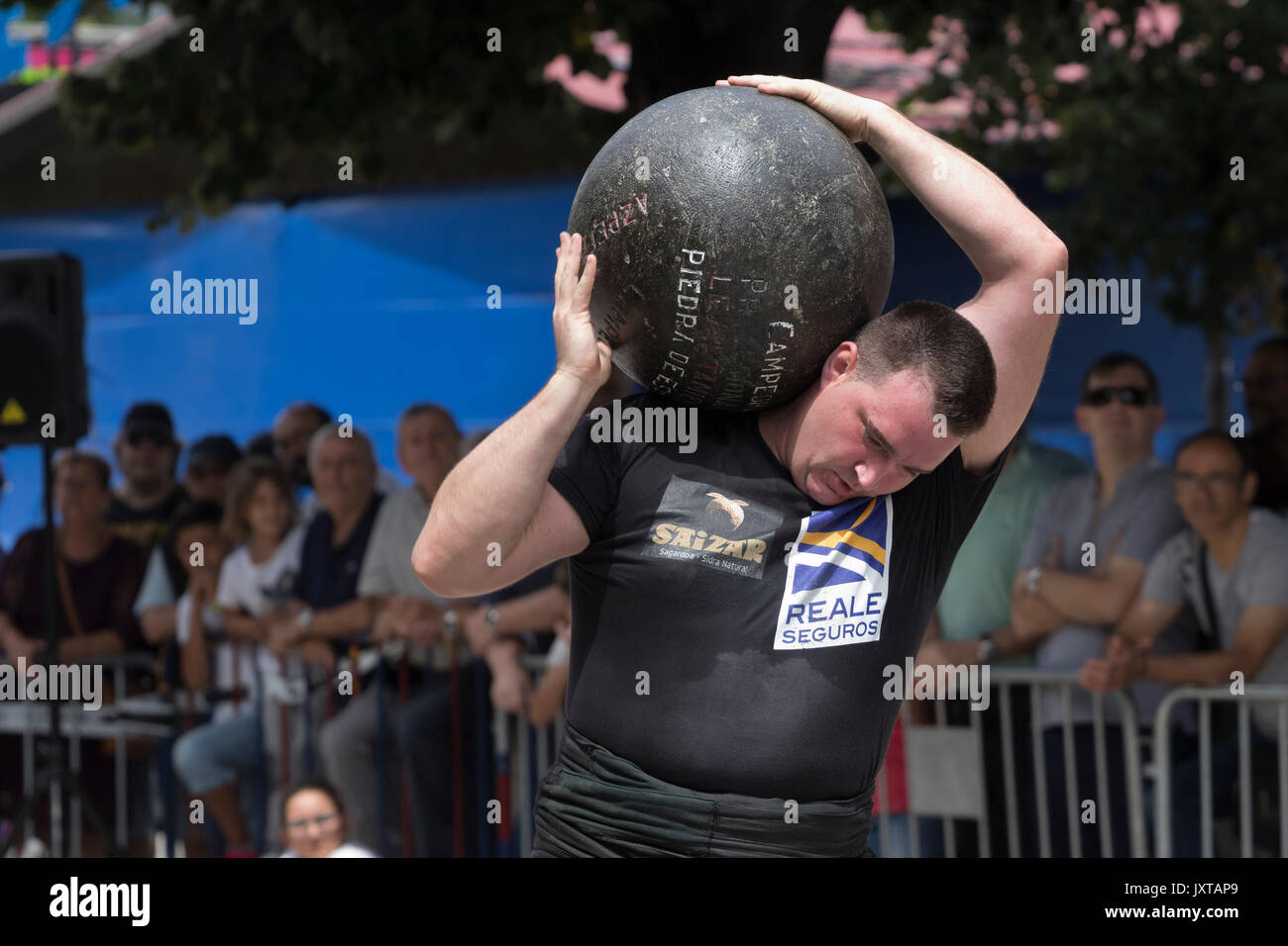 Basque stone lifter with a huge round stone in a competition. Stock Photo