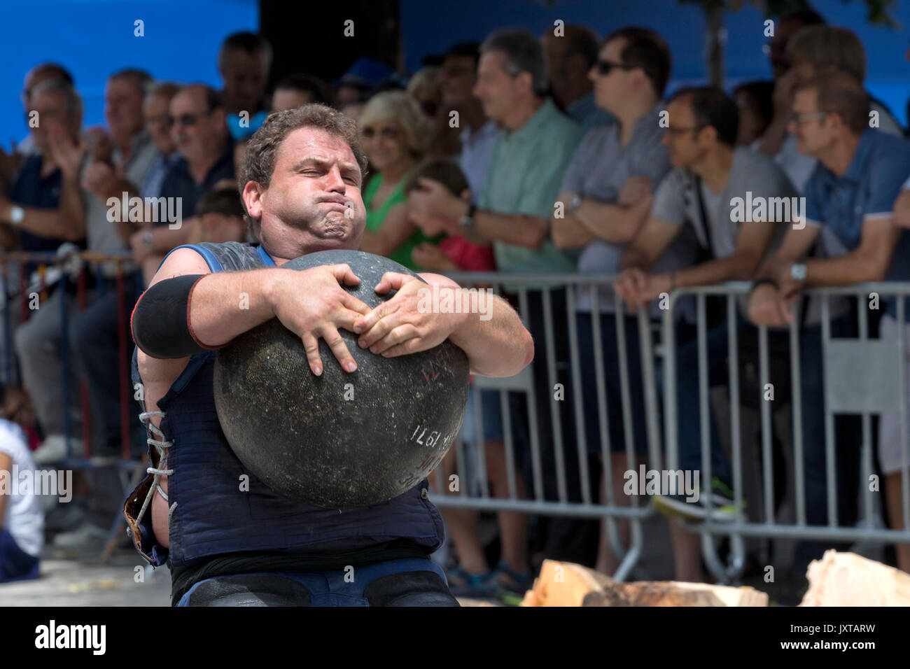 Basque stone lifter (harrijasotzaile) lifting a round stone in a competition. Stock Photo