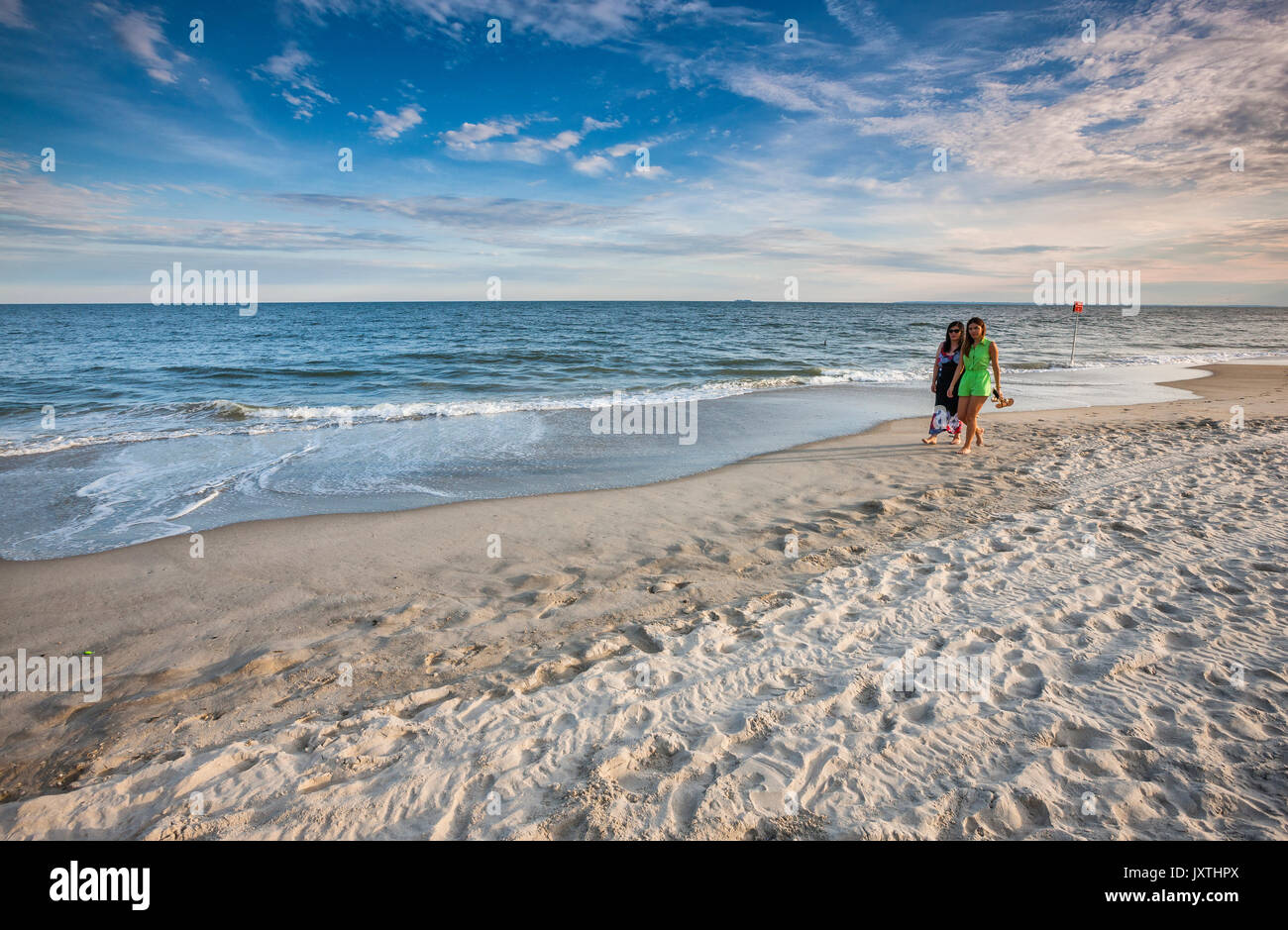 Two tourists walking on the Rockaway beach, Long Island, New york Stock Photo
