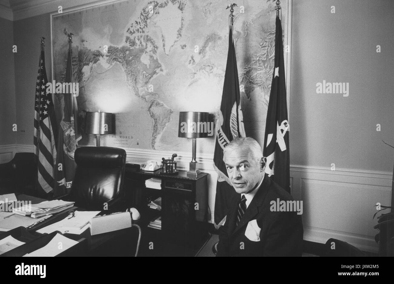 Paul Henry Nitze, Candid photograph, Nitze sitting in Secretary of Navy office with large map of world on wall behind him, 1964. Stock Photo