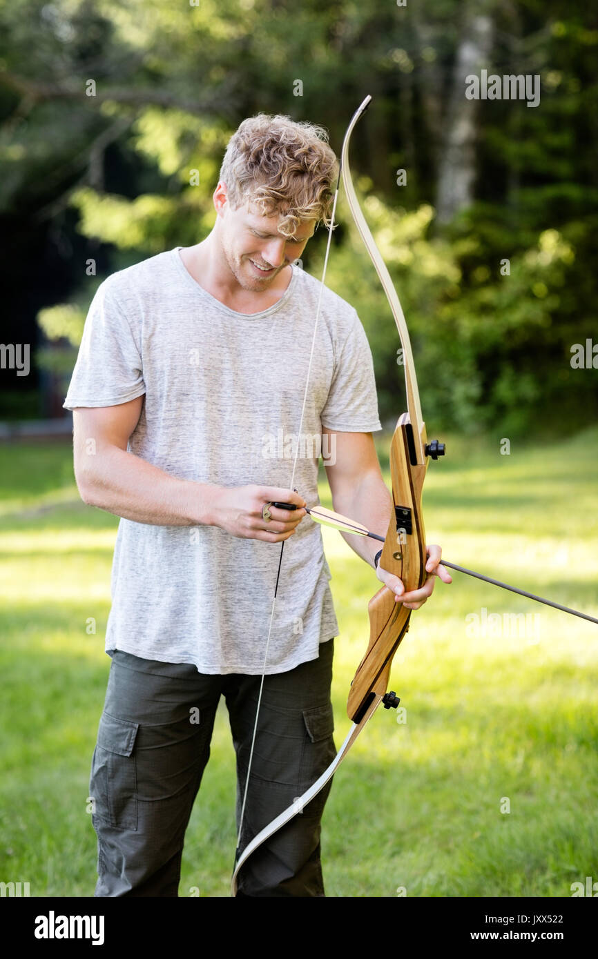 Confident Male Archer Holding Bow And Arrow In Forest Stock Photo Alamy