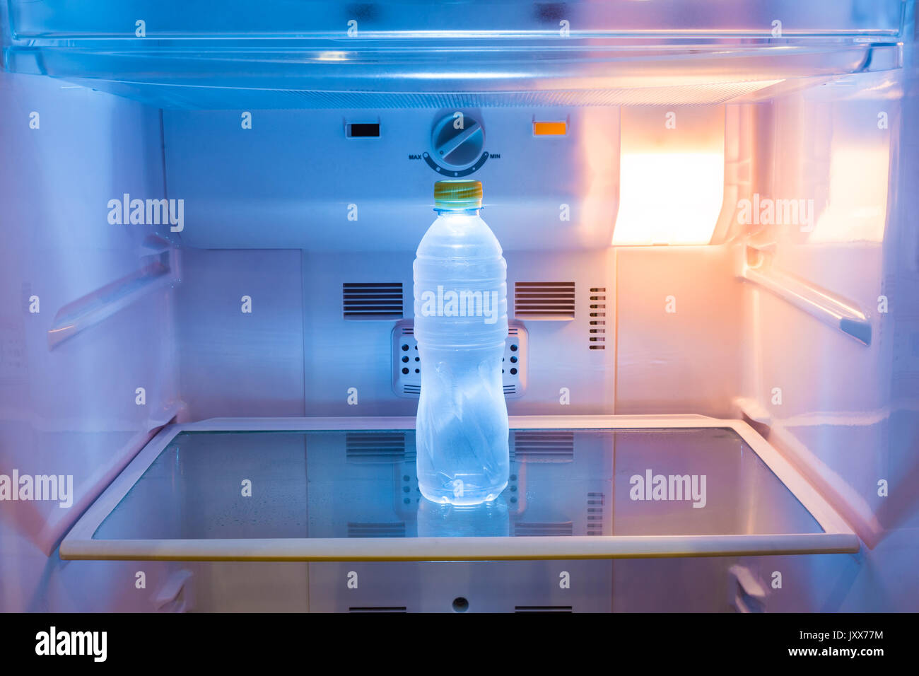 https://c8.alamy.com/comp/JXX77M/single-cold-water-bottle-on-a-shelf-in-refridgerator-with-warm-light-JXX77M.jpg