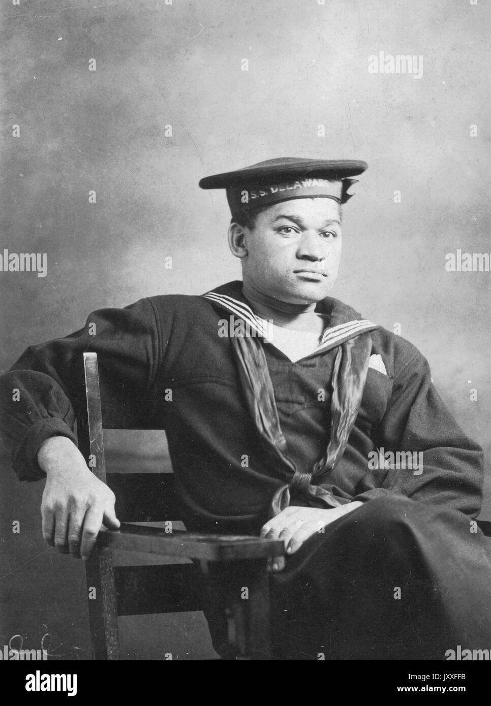 Three-quarters portrait of an African American World War I US Navy sailor, seated, wearing uniform, neutral facial expression, 1920. Stock Photo