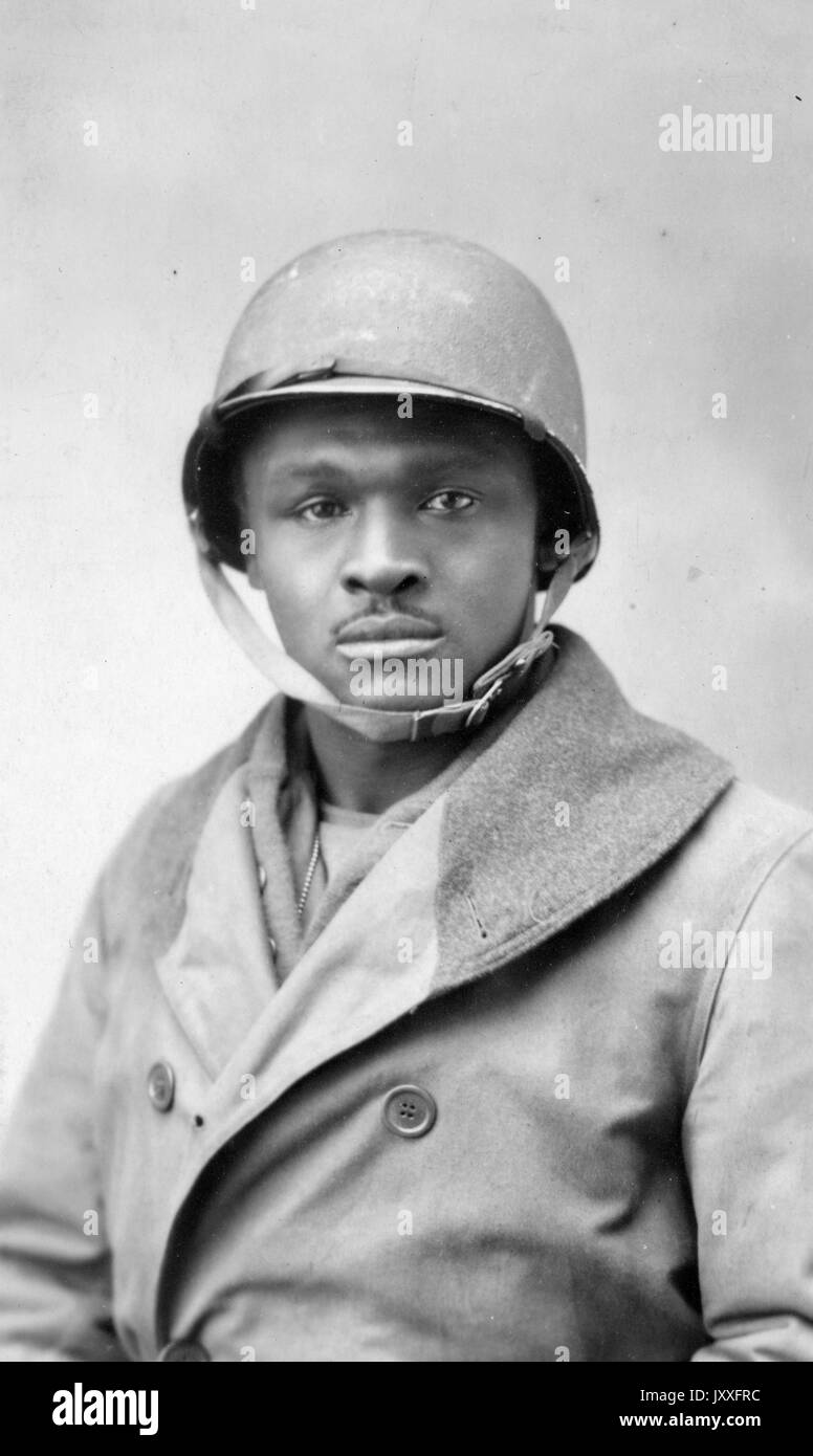 Half portrait of an African American World War I solder, wearing a double-breasted jacket and helmet, neutral facial expression, 1920. Stock Photo