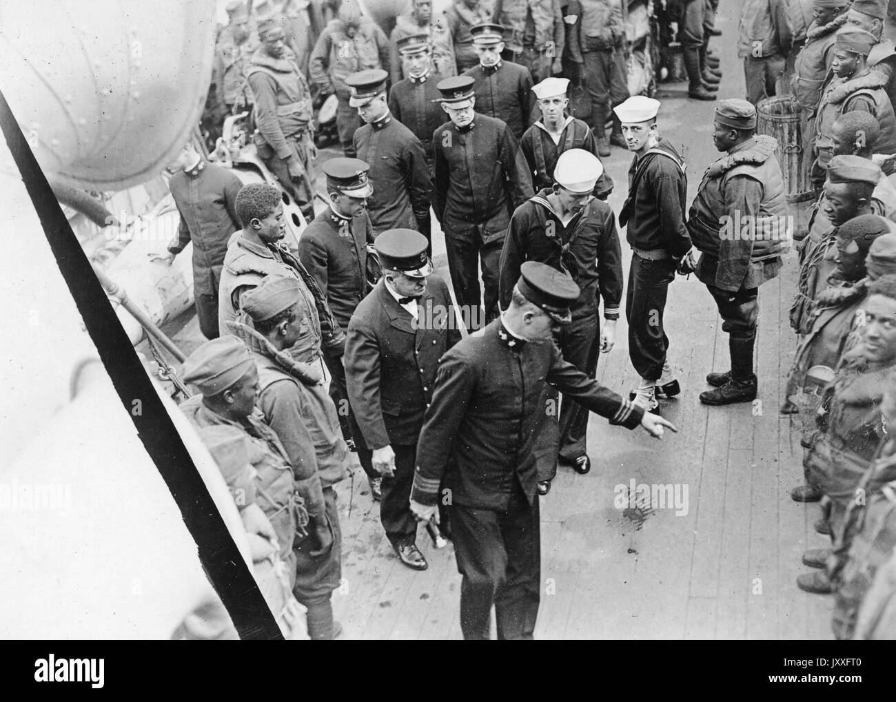 Aerial landscape shot of highly ranked military officials inspecting African American soldiers standing in lines, leading official pointing to shoes of one soldier, World War I US Navy, 1917. Stock Photo