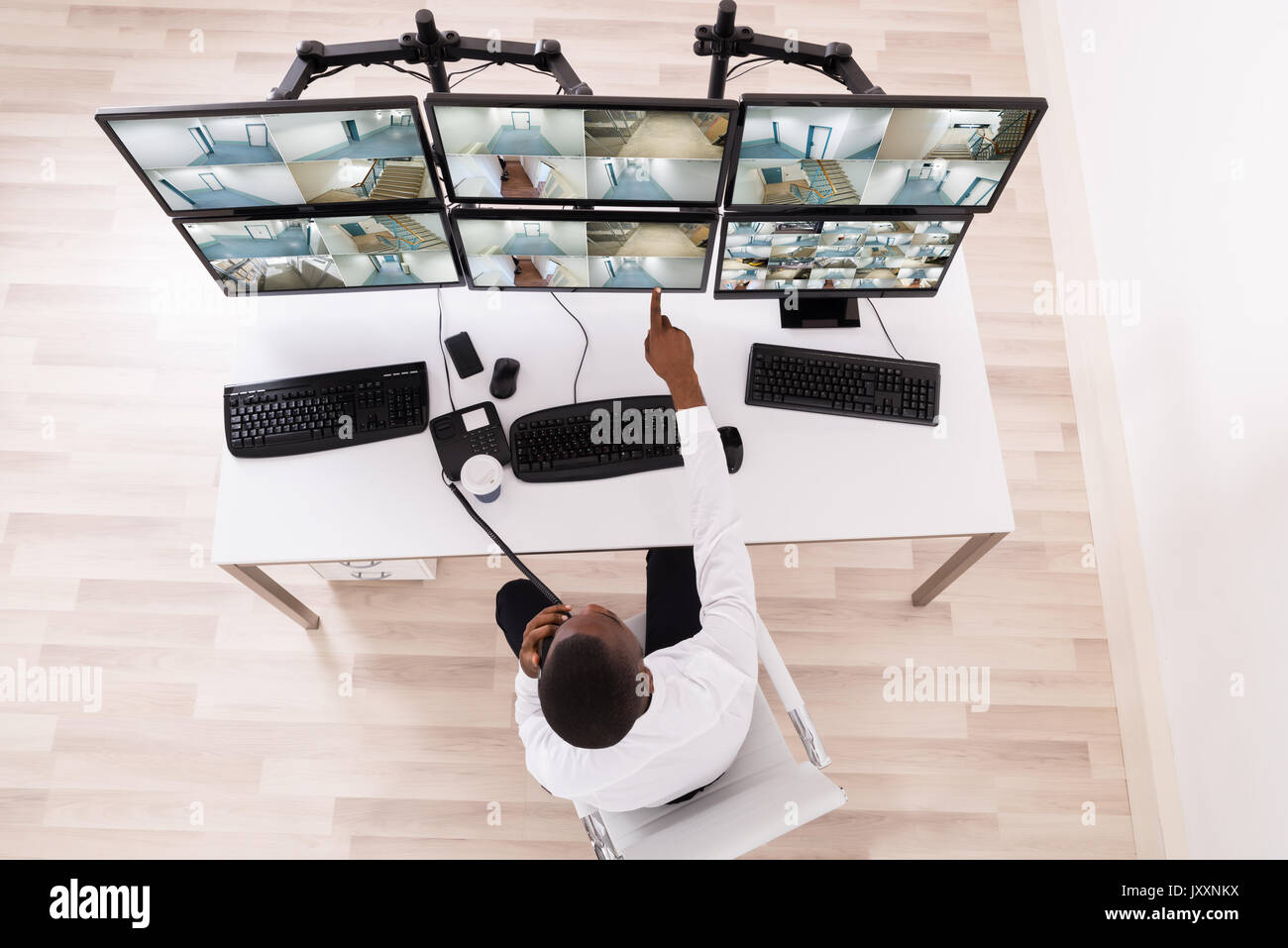 High Angle View Of Male Operator Pointing At CCTV Footage On Computer ...