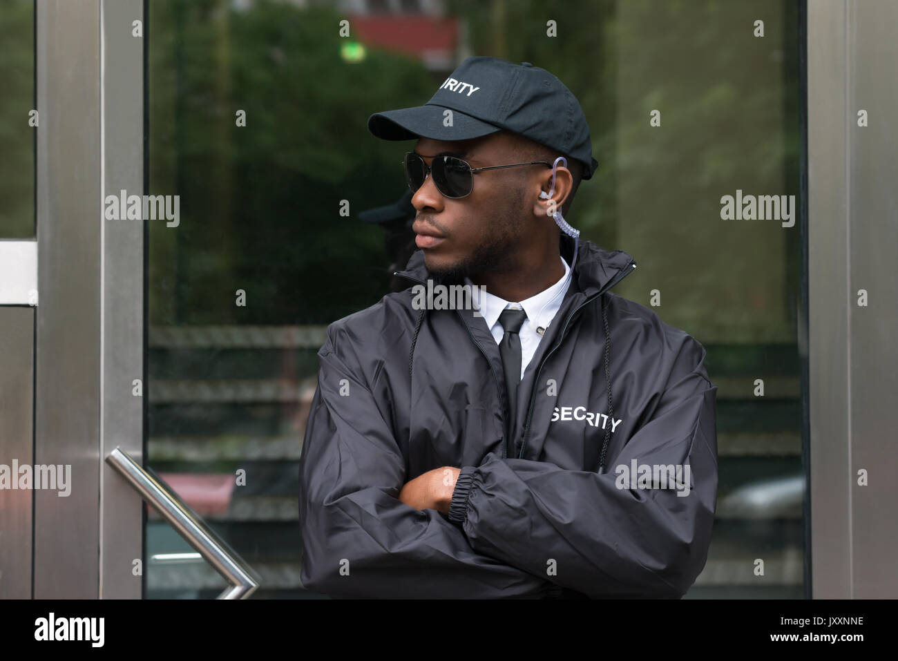 Portrait Of Young African Male Security Guard Standing Arms Crossed