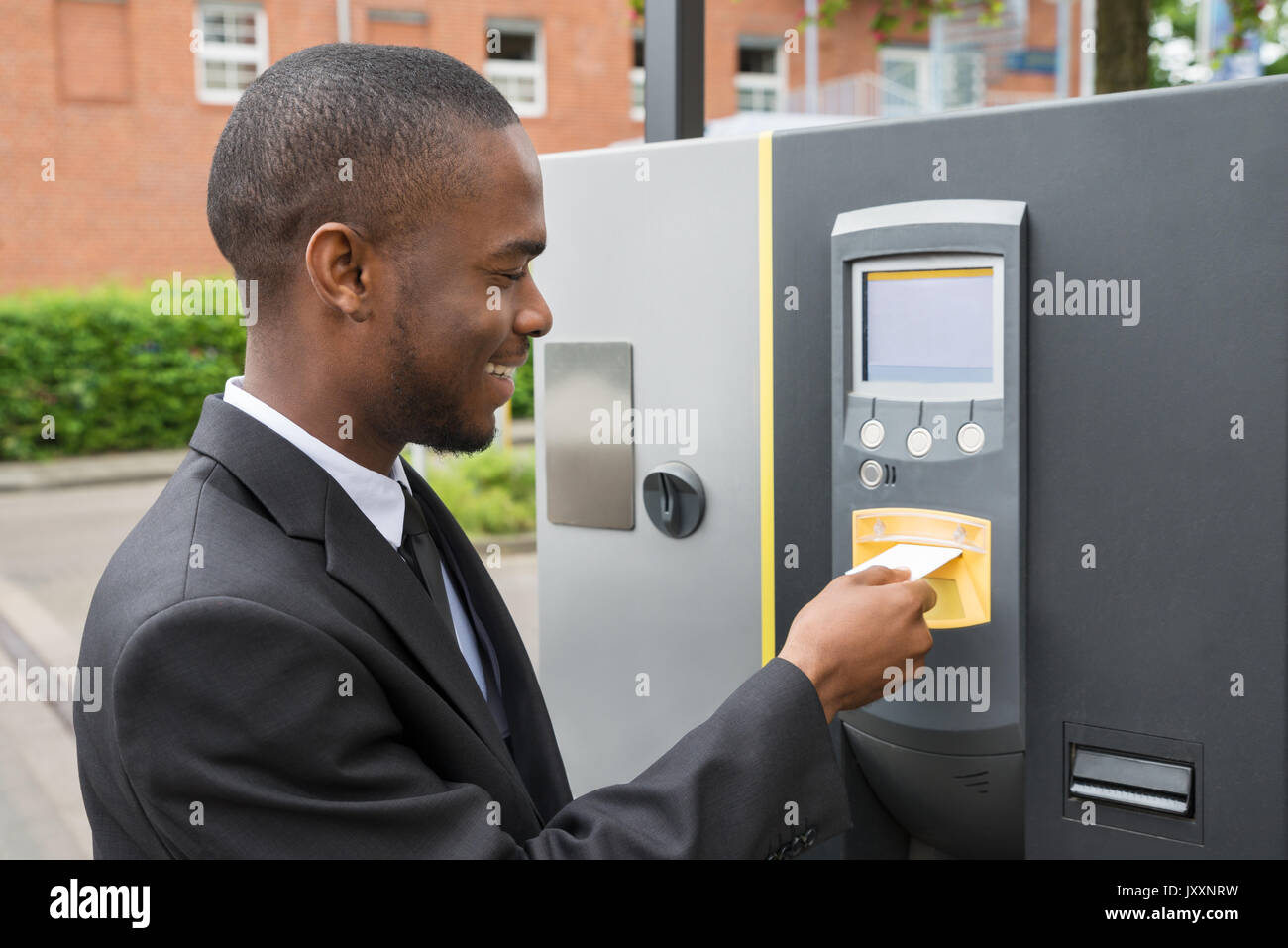Happy Young Businessman Inserting Ticket Into Parking Machine To Pay For Parking Stock Photo Alamy