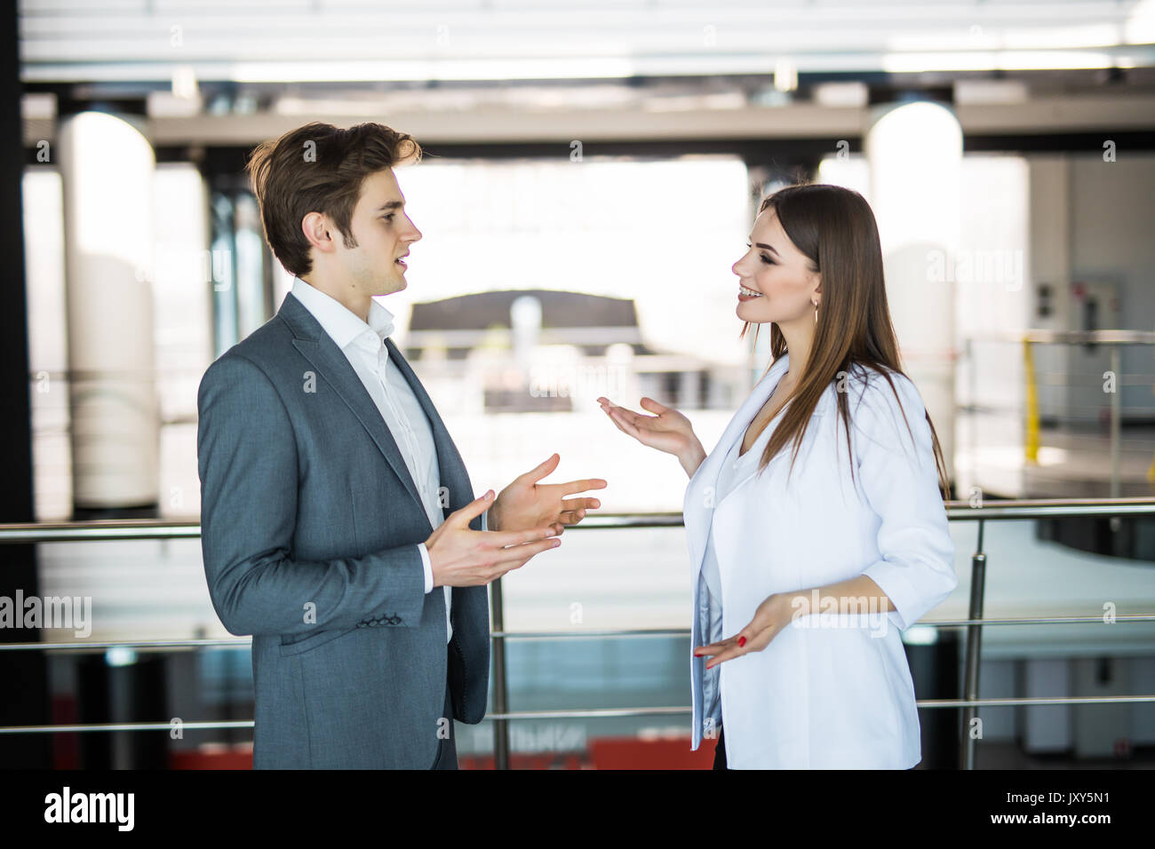 Handsome businessman discuss with businesswoman at the beginning of a meeting in front of panoramic window Stock Photo