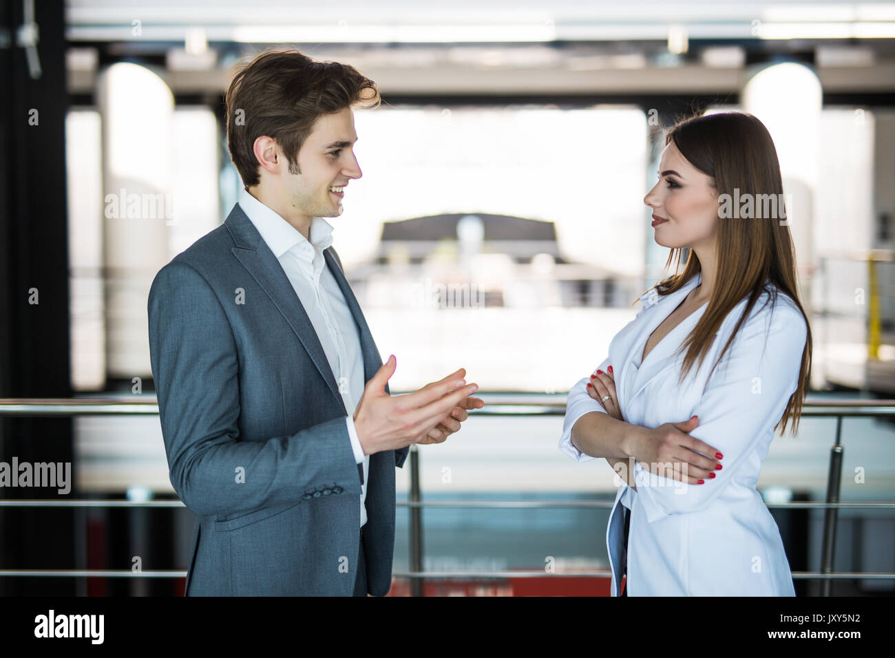 Handsome businessman discuss with businesswoman at the beginning of a meeting in front of panoramic window Stock Photo