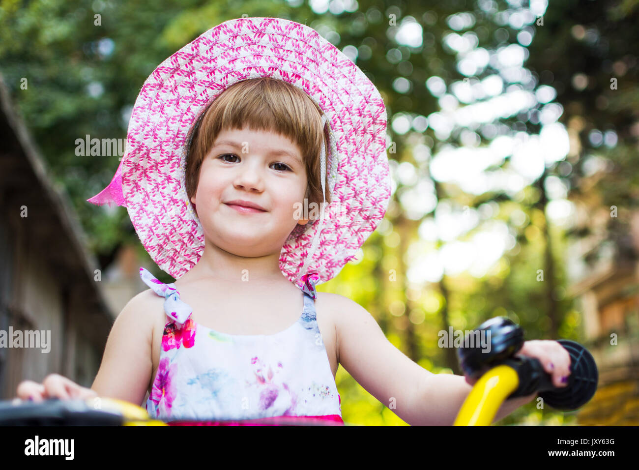 Cute girl learning to ride a bicycle outdoors Stock Photo