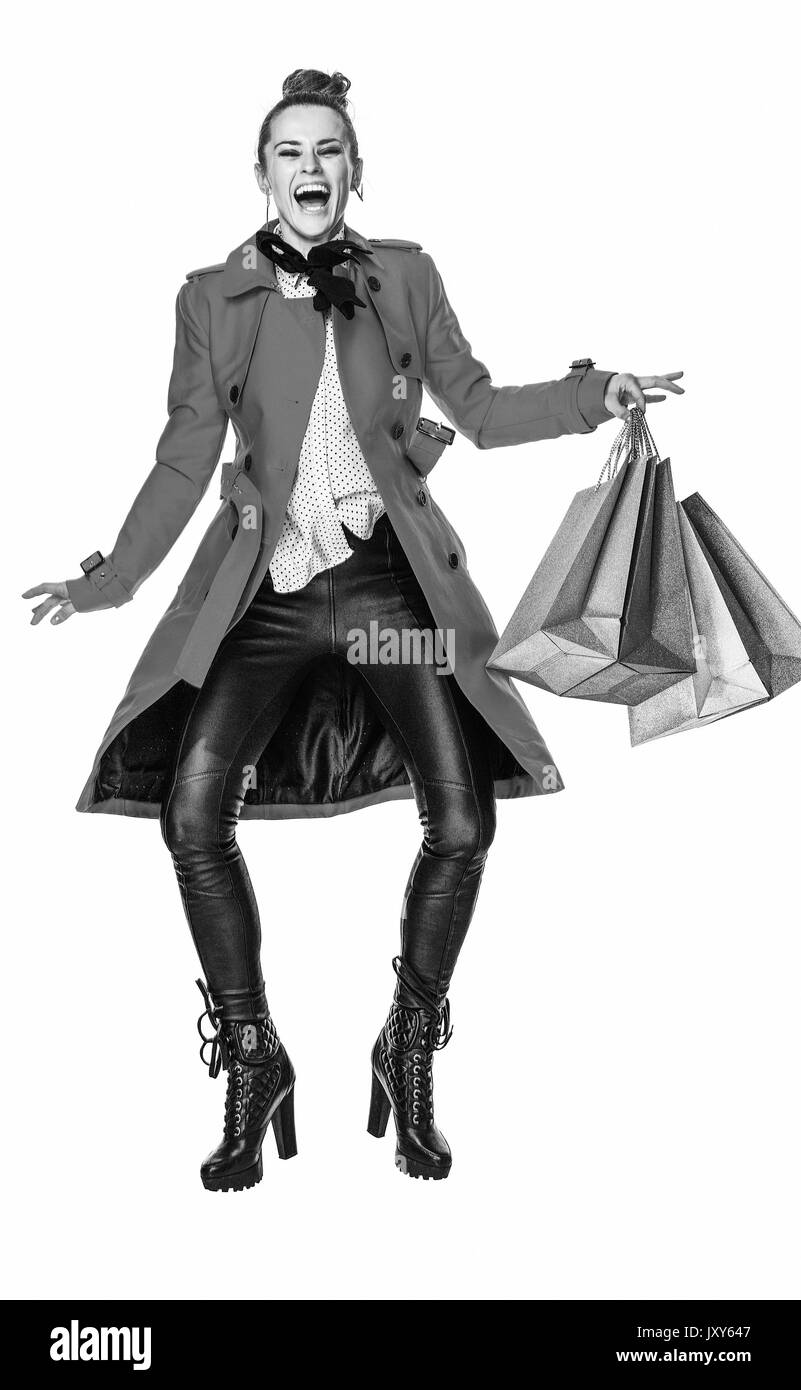 Keep the autumn bright. Full length portrait of happy modern woman in red coat isolated on white background jumping with shopping bags Stock Photo