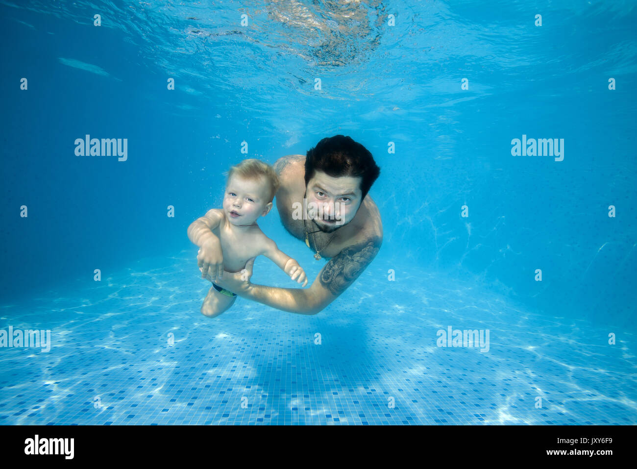 Dad and son playing under water in the pool Stock Photo