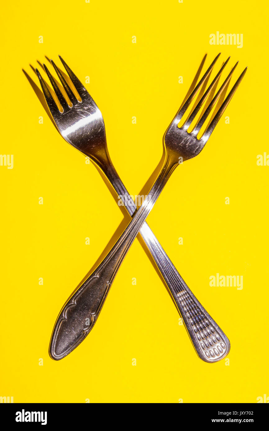 Two Forks on Yellow Background Stock Photo