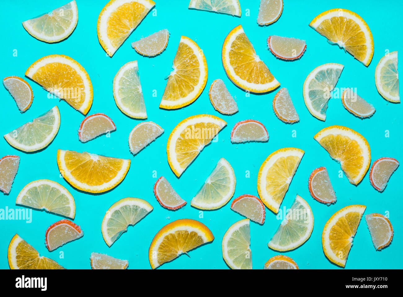 Orange and lemon slices and sweets on blue background Stock Photo