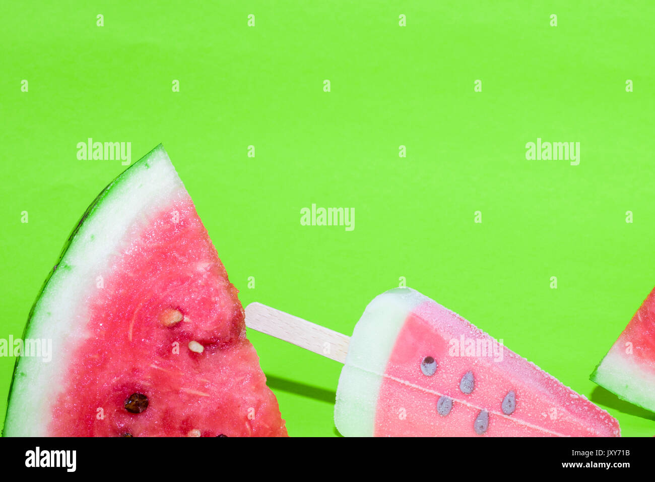 Watermelon slice and ice cream on bright green background Stock Photo