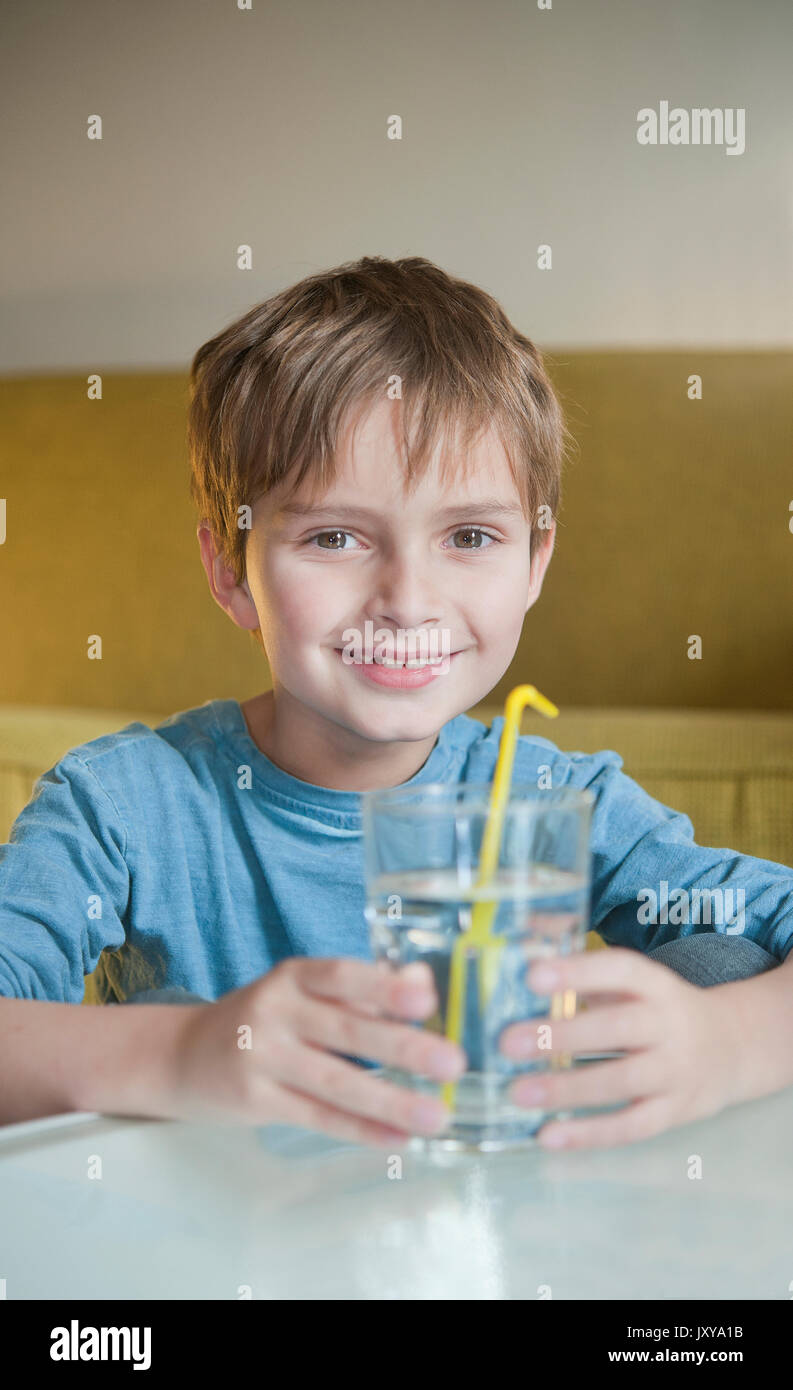 7-year old boy drinking water through a straw Stock Photo