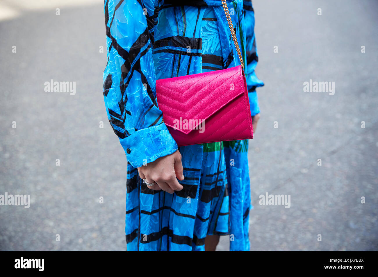 Mid section of a woman in blue dress with pink leather bag Stock Photo