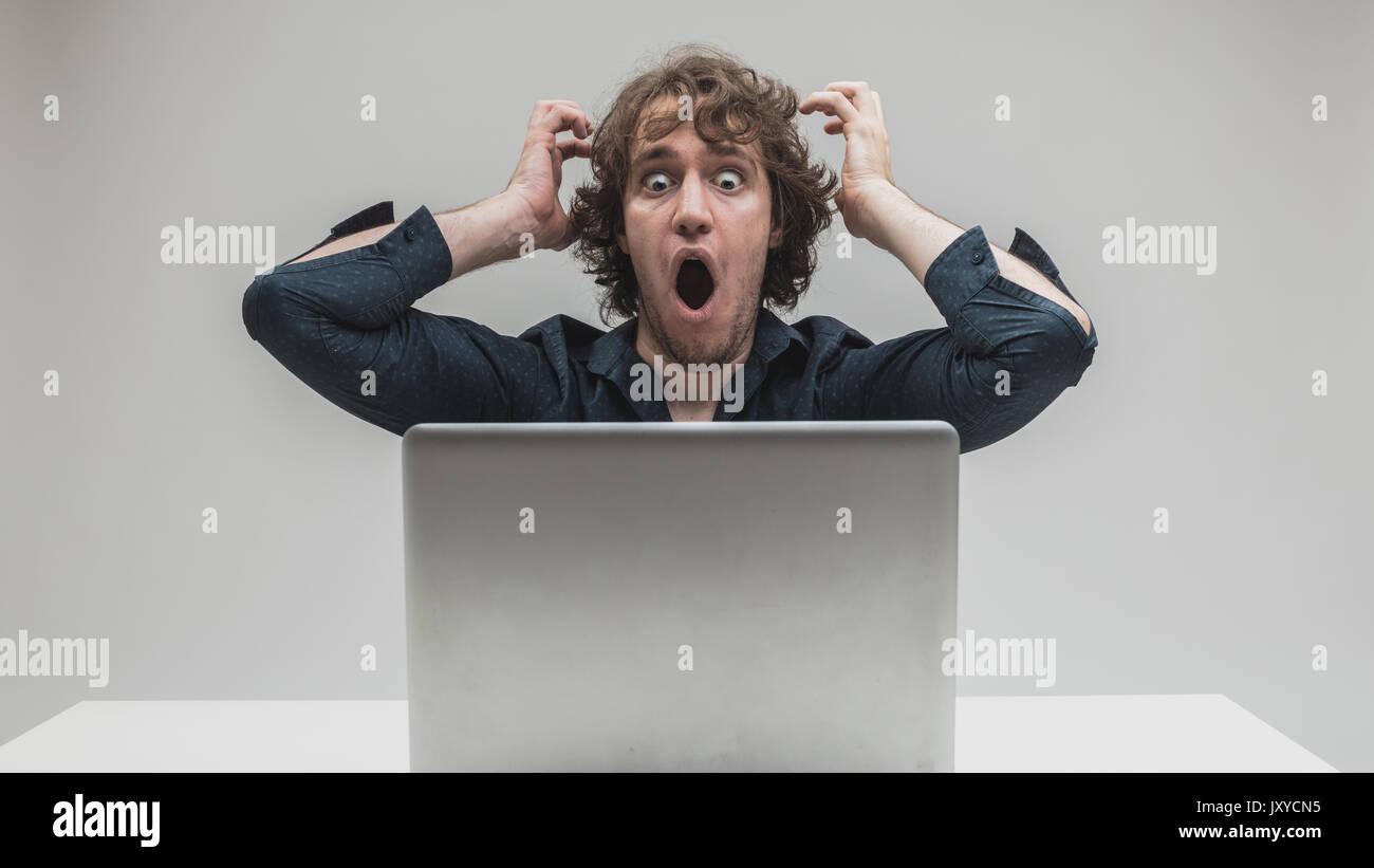 businessman very shocked about something he just viewed or read on the internet or viruses or application problems Stock Photo