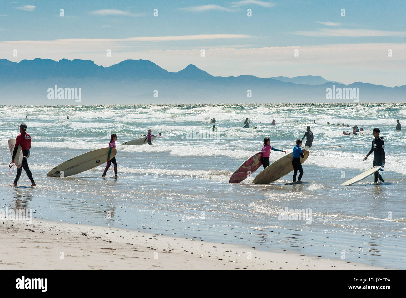 Surfers and bathers at Muizenberg Beach in Cape Town, South Africa. Stock Photo