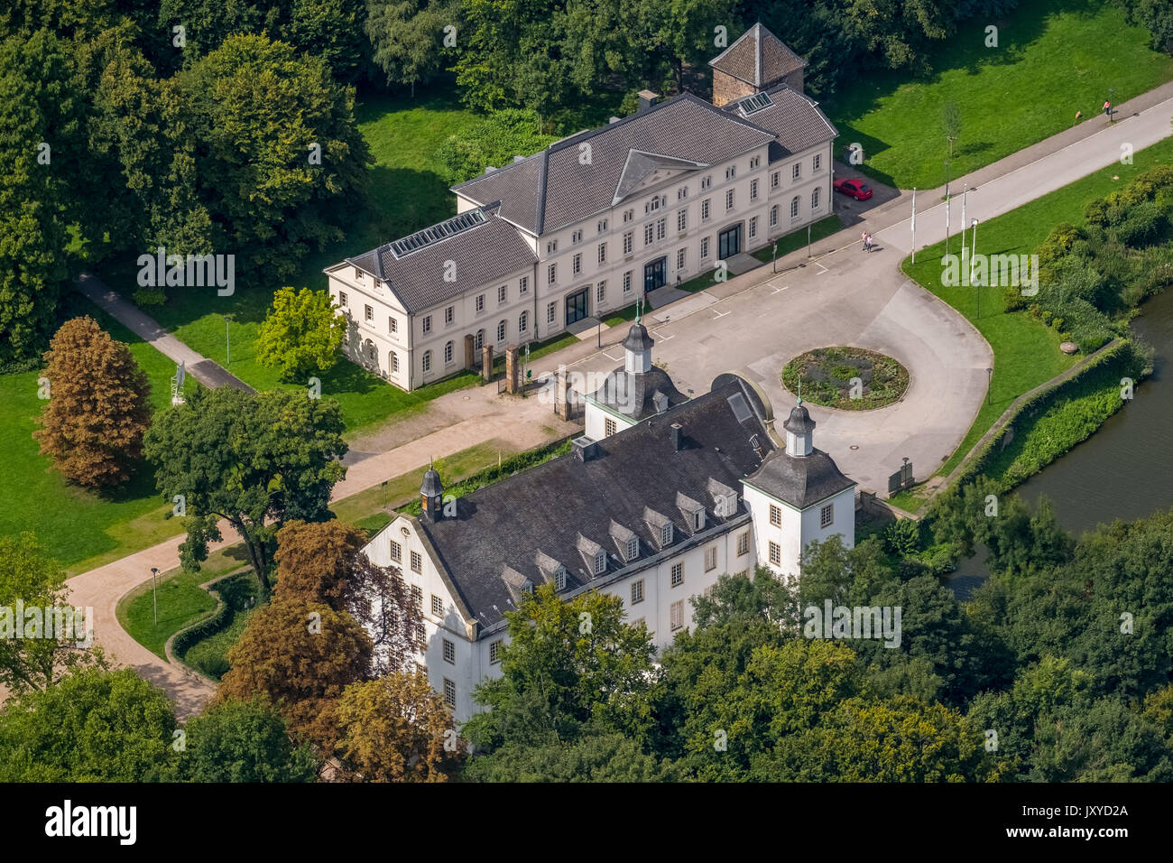 Schloss Borbeck, baroque moated castle, main house and an elongated farm buildings, curly gable, castle park is designed as an English landscape garde Stock Photo