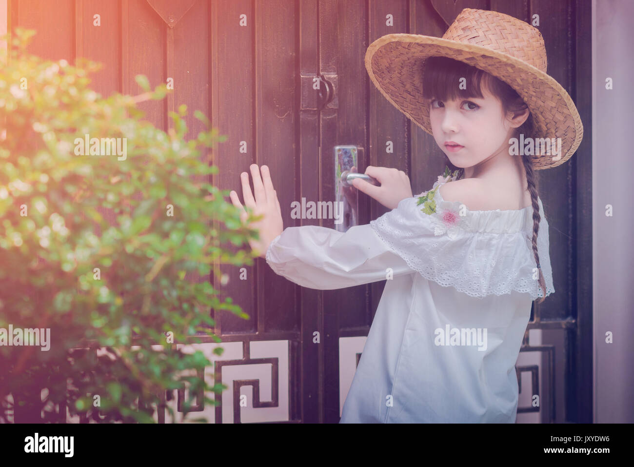 a little cute girl alone in the garden or farm and outside in nature Stock Photo